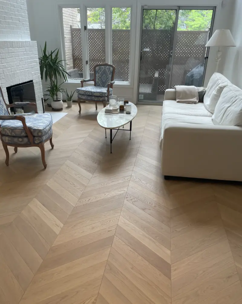 An interior installation photo showcasing the Vali chevron wood flooring pattern